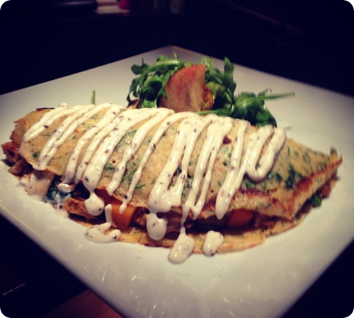 Chickpea Crepe - filled with sauteed wild mushrooms, grilled chili tempeh, butternut squash, and spinach with a garlic truffle aoli.